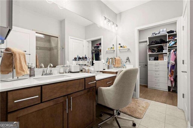 bathroom featuring hardwood / wood-style floors, vanity, and a shower with shower door