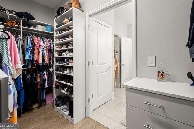 walk in closet with light tile patterned flooring