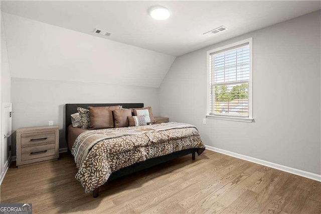 bedroom with light hardwood / wood-style flooring and lofted ceiling