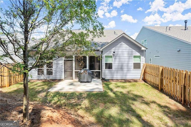 rear view of house with a lawn and a patio area