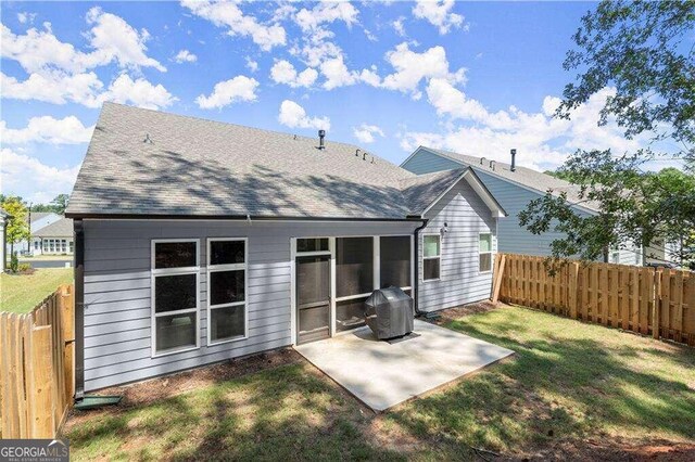 rear view of property with a yard and a patio