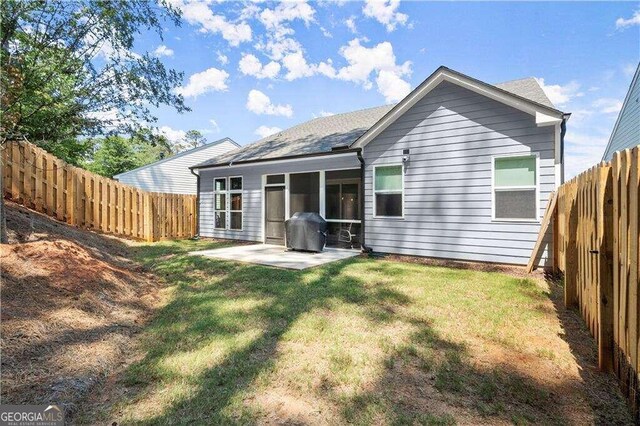 back of house with a patio and a lawn