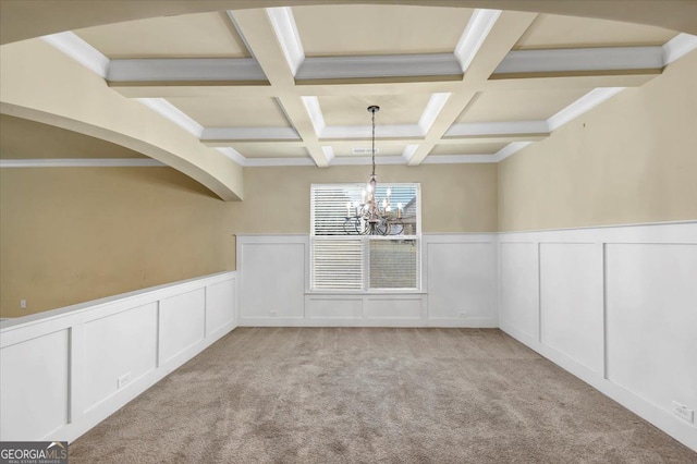 unfurnished room featuring crown molding, coffered ceiling, an inviting chandelier, beamed ceiling, and light colored carpet