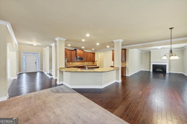 kitchen with stainless steel appliances, light stone countertops, dark hardwood / wood-style flooring, and tasteful backsplash