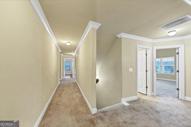 corridor with ornamental molding and light carpet