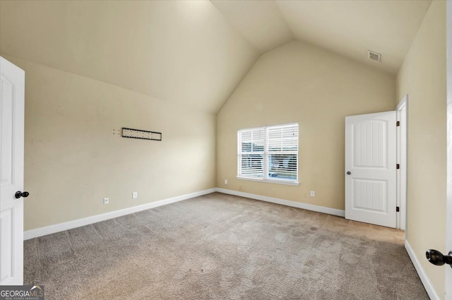 unfurnished room featuring lofted ceiling and light carpet