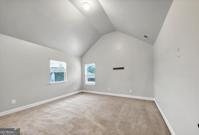 carpeted empty room featuring lofted ceiling