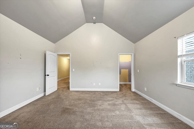 unfurnished bedroom featuring lofted ceiling and light carpet