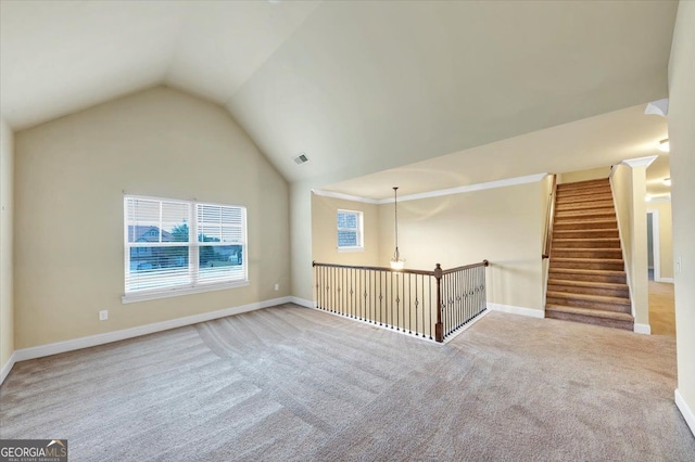 spare room with light carpet and vaulted ceiling