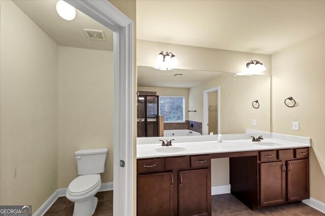 bathroom with tile patterned flooring, a bath, toilet, and vanity