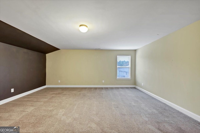 empty room with light carpet and vaulted ceiling