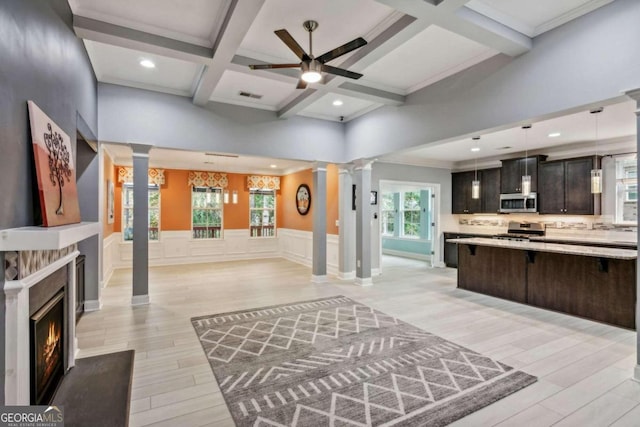 interior space featuring decorative columns, a wealth of natural light, ceiling fan, and coffered ceiling