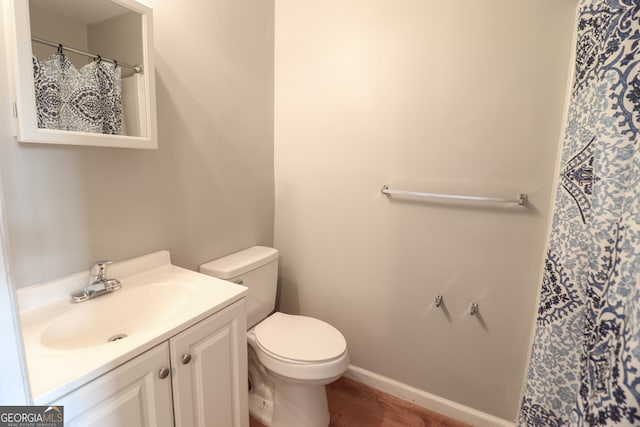 bathroom with hardwood / wood-style floors, vanity, and toilet