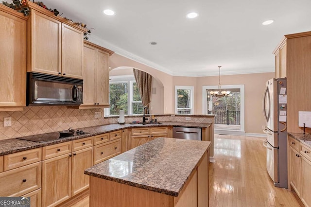 kitchen with light hardwood / wood-style flooring, black appliances, a kitchen island, and a notable chandelier