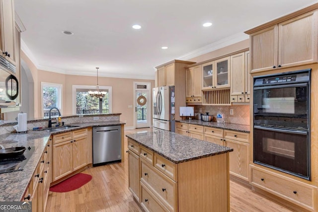 kitchen featuring an inviting chandelier, black appliances, sink, pendant lighting, and light wood-type flooring