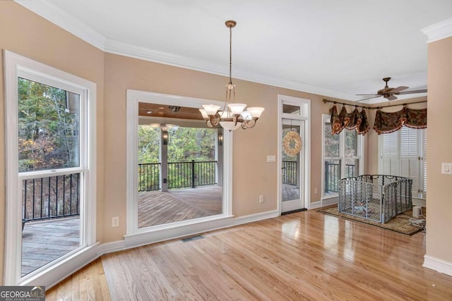 interior space featuring a wealth of natural light, ceiling fan with notable chandelier, crown molding, and light hardwood / wood-style flooring