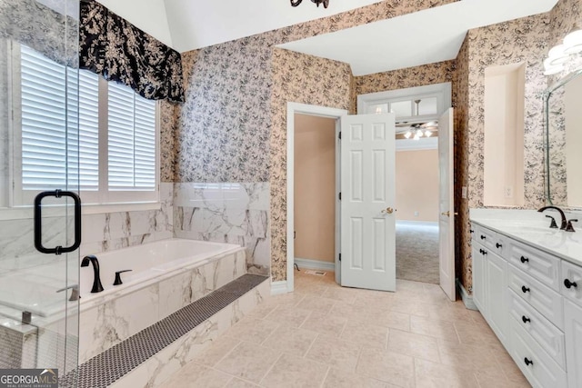 bathroom featuring vanity, lofted ceiling, ceiling fan, and tiled tub