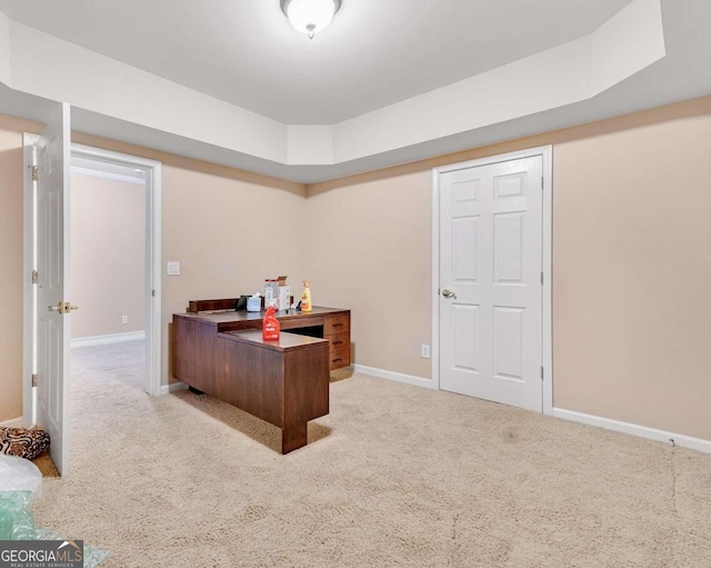 office area featuring light carpet and a raised ceiling