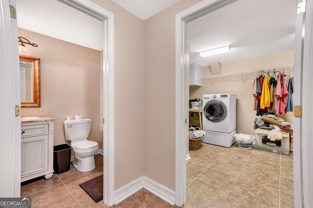 clothes washing area featuring washer / clothes dryer and light tile patterned flooring