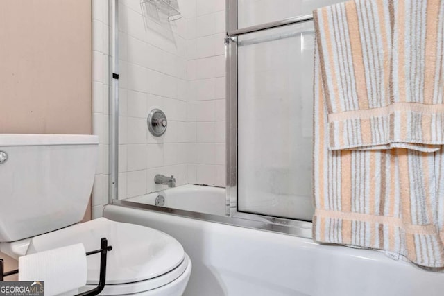 bathroom with shower / bath combination with glass door and toilet