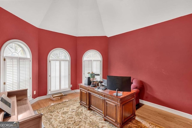 home office featuring light wood-type flooring and vaulted ceiling