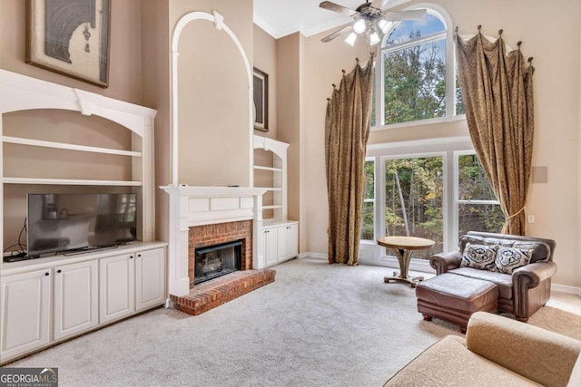 living room featuring a towering ceiling, light carpet, and a healthy amount of sunlight