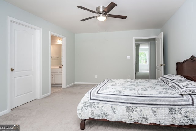 bedroom with light carpet, ceiling fan, and ensuite bath