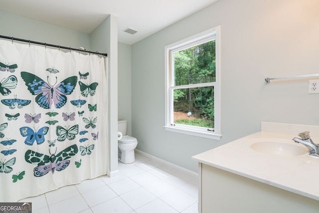 bathroom with tile patterned floors, toilet, vanity, and plenty of natural light