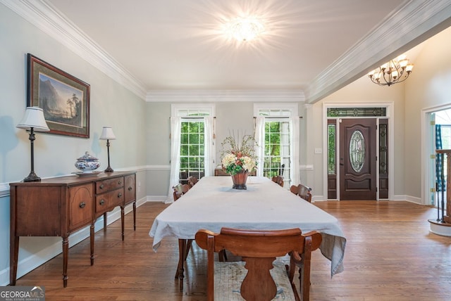 dining area featuring ornamental molding, dark wood-type flooring, and a notable chandelier