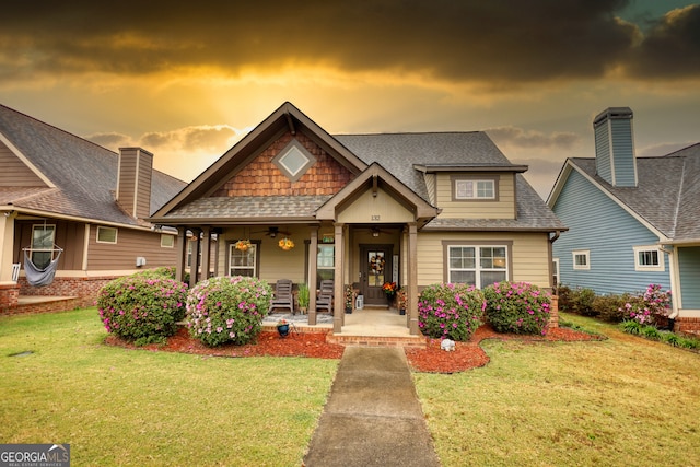 craftsman-style house featuring covered porch and a yard