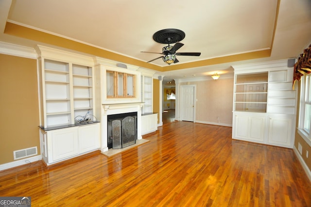 unfurnished living room featuring ornamental molding, ceiling fan, and wood-type flooring