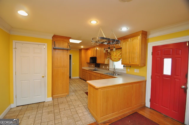 kitchen with sink, black appliances, crown molding, and kitchen peninsula