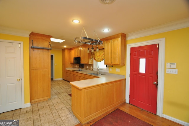 kitchen with sink, ornamental molding, black appliances, and kitchen peninsula