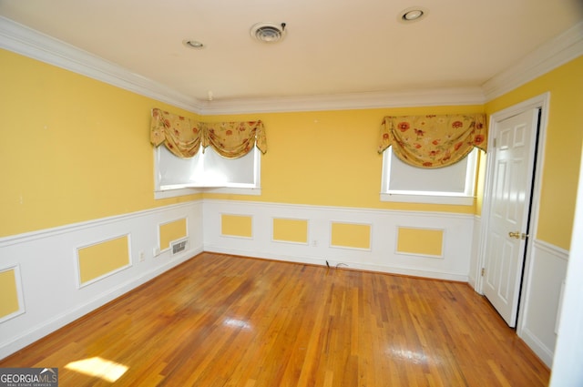 empty room featuring crown molding and hardwood / wood-style flooring