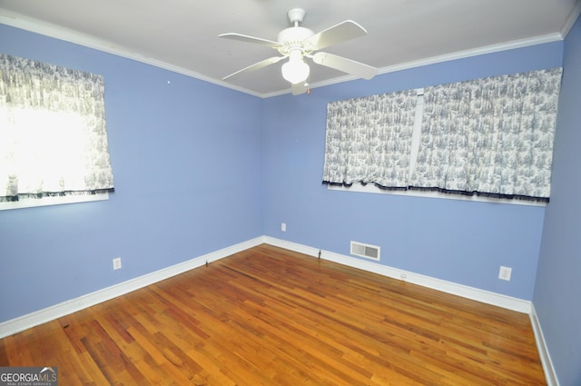 empty room featuring ornamental molding, ceiling fan, and hardwood / wood-style floors