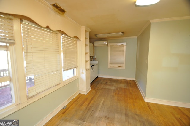 hall featuring a wall mounted air conditioner, light hardwood / wood-style floors, and crown molding