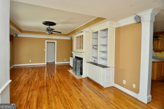 unfurnished living room featuring ceiling fan, crown molding, and light hardwood / wood-style flooring