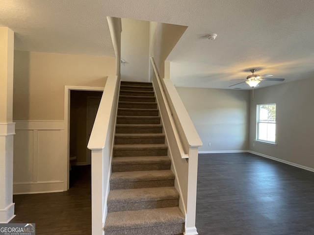 staircase with ceiling fan and hardwood / wood-style flooring