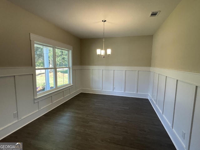 unfurnished dining area with dark hardwood / wood-style flooring and a notable chandelier