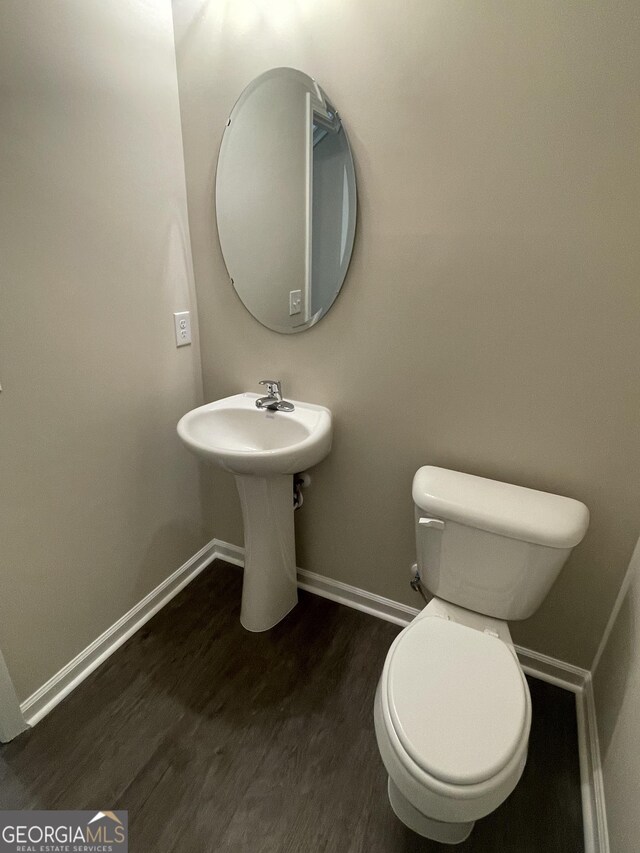 bathroom featuring wood-type flooring and toilet