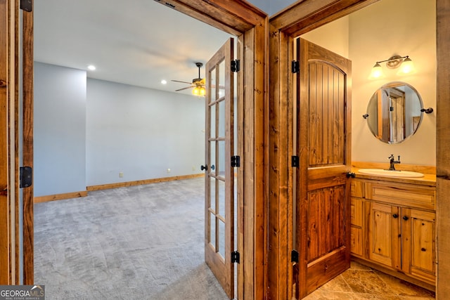 corridor with sink and light colored carpet