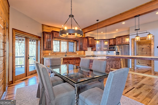 dining area with light hardwood / wood-style floors, a chandelier, and french doors