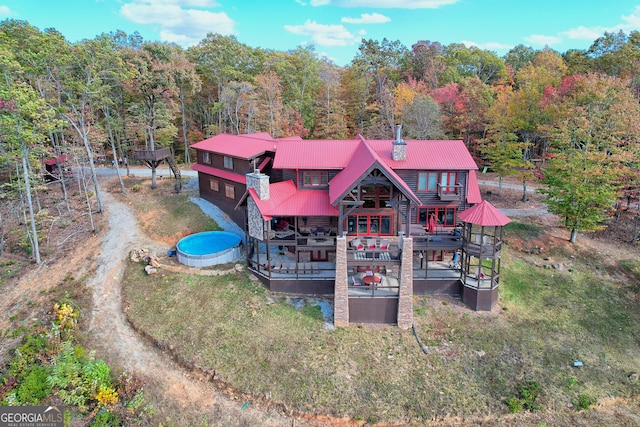 back of house featuring a lawn and a deck