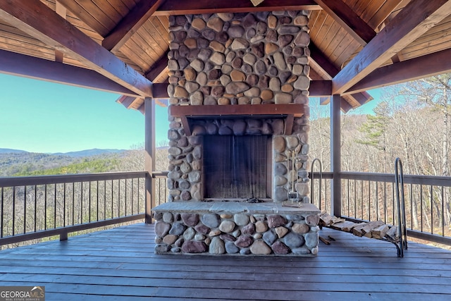 deck featuring a mountain view and an outdoor stone fireplace