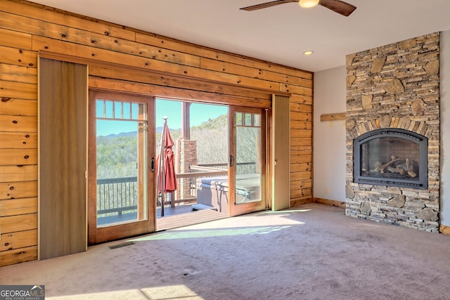 unfurnished living room featuring carpet flooring, ceiling fan, and a fireplace