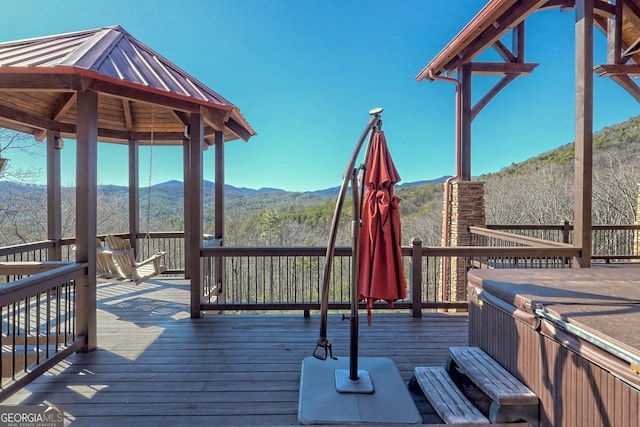 wooden terrace featuring a mountain view, a gazebo, and a hot tub