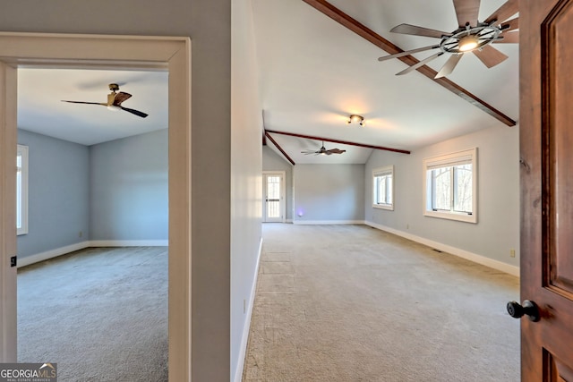 spare room featuring light carpet and vaulted ceiling