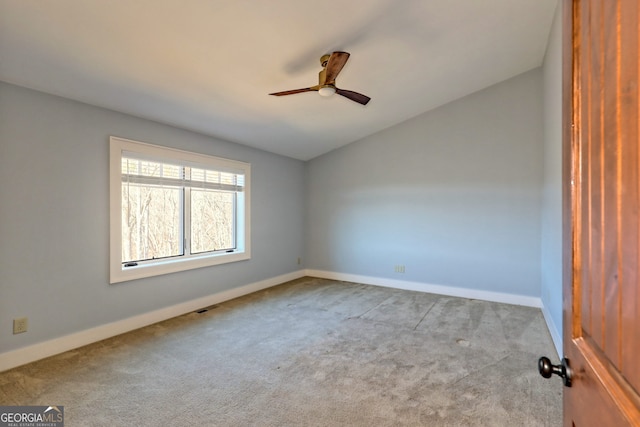 empty room with lofted ceiling, light colored carpet, and ceiling fan