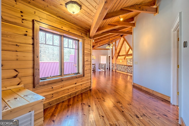 spare room with wooden ceiling, wooden walls, and vaulted ceiling with beams