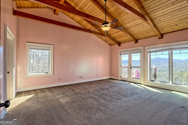 carpeted spare room featuring a mountain view, french doors, beamed ceiling, and wood ceiling